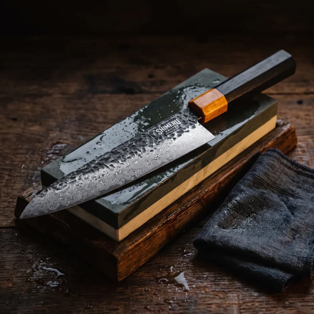 Kumozu 8'' Damascus Steel Gyuto Knife being sharpened on a wet whetstone