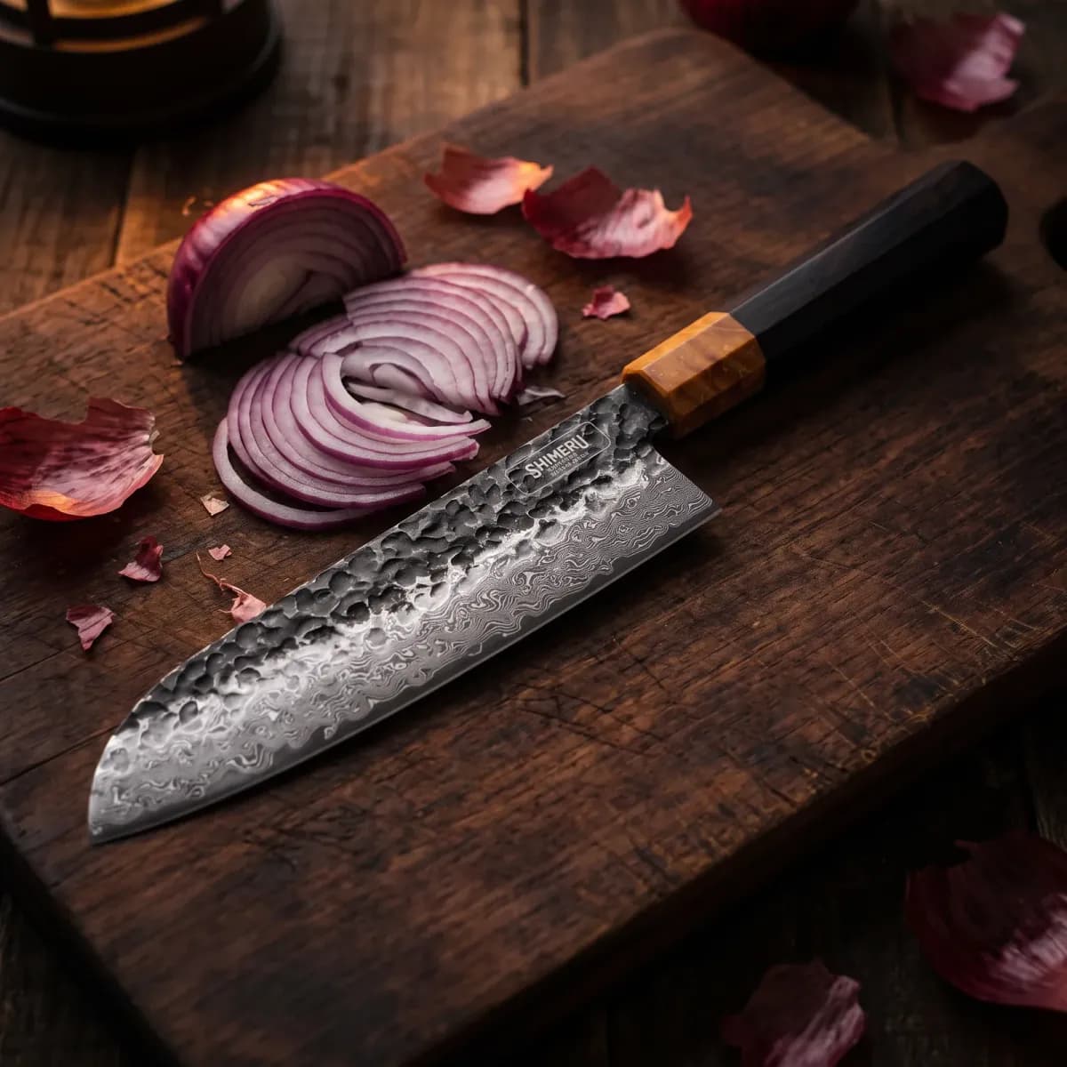 Dark Grain 7" Damascus Steel Santoku Knife beside a thinly sliced red onion
